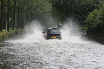 Car driving through a flooded street