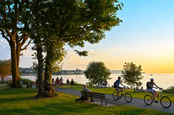 People cycling, walking or jogging during late afternoon in park.