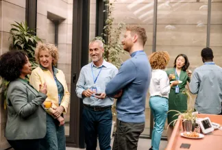 Group of business people having casual conversation while on a refreshment break.
