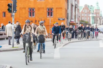 People going by bike in the city. A lot of commuters, students and tourists prefer using bike instead of car or bus to move around the city.